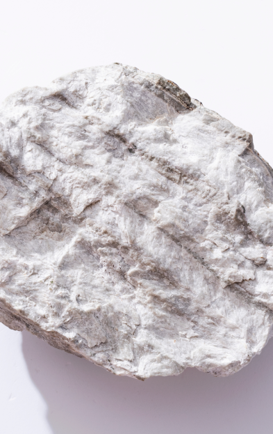 Una persona trabajando en una mina, lleva un chaleco amarillo y un casco blanco